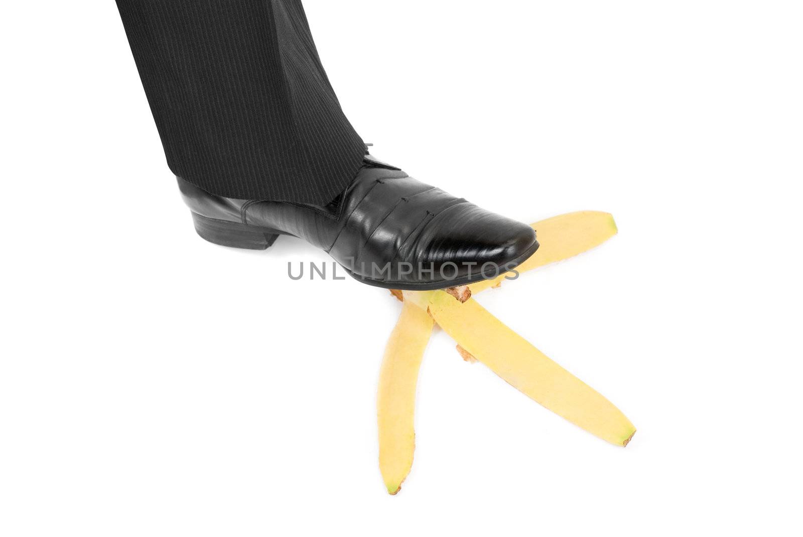 Business boot to step on a banana skin on a white
