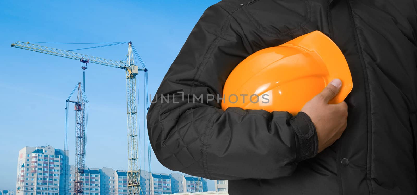 Closeup of builder with helmet on building panorama background