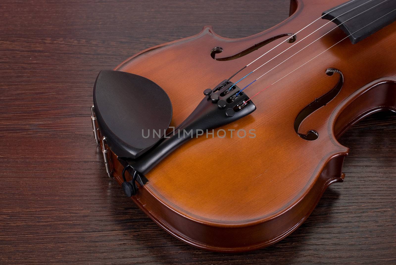 violin on a brown wooden background closeup