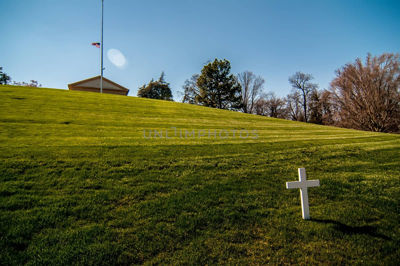 white cross on a grassy hill