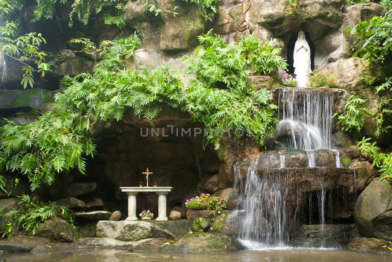 Waterfalls in the park. A statue of the goddess. Of Christianity.