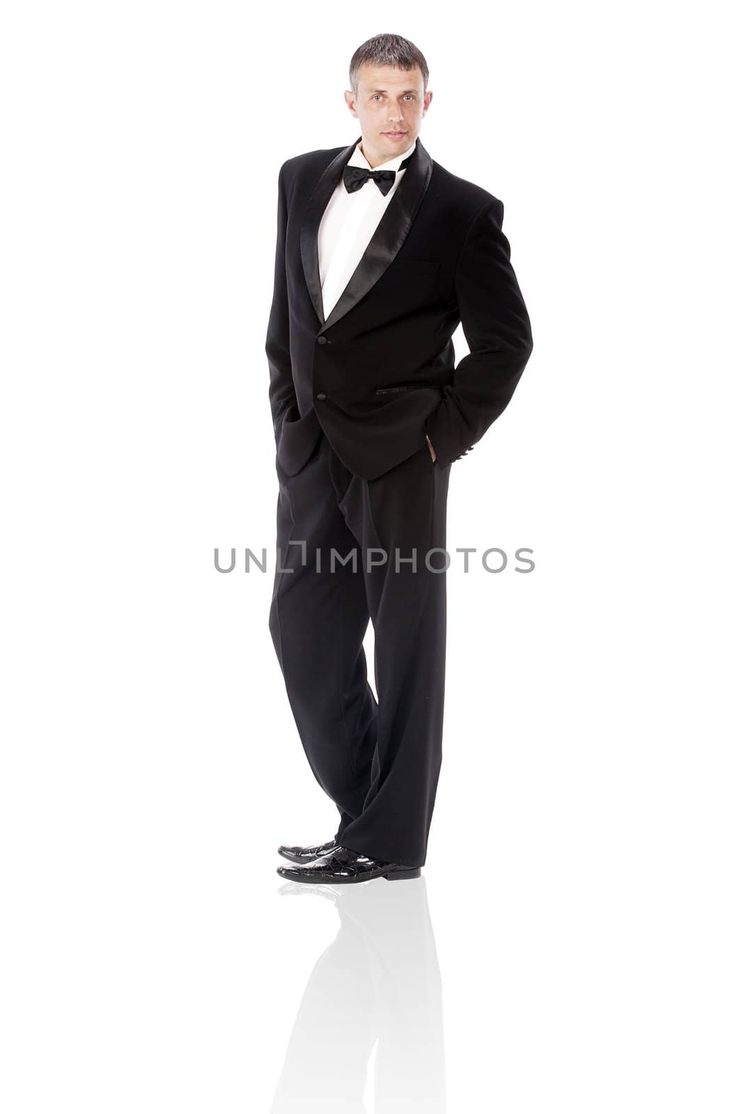 The elegant man in a classical tuxedo on a white background