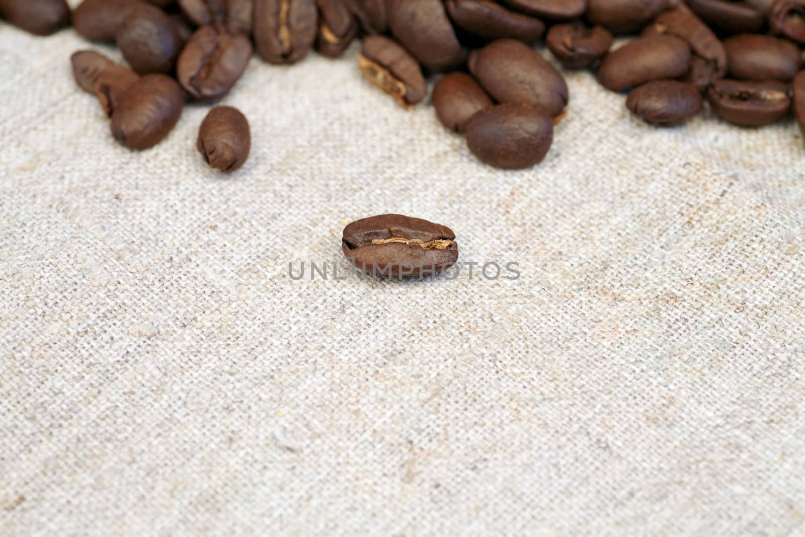 scented coffee beans scattered on a beige braided material