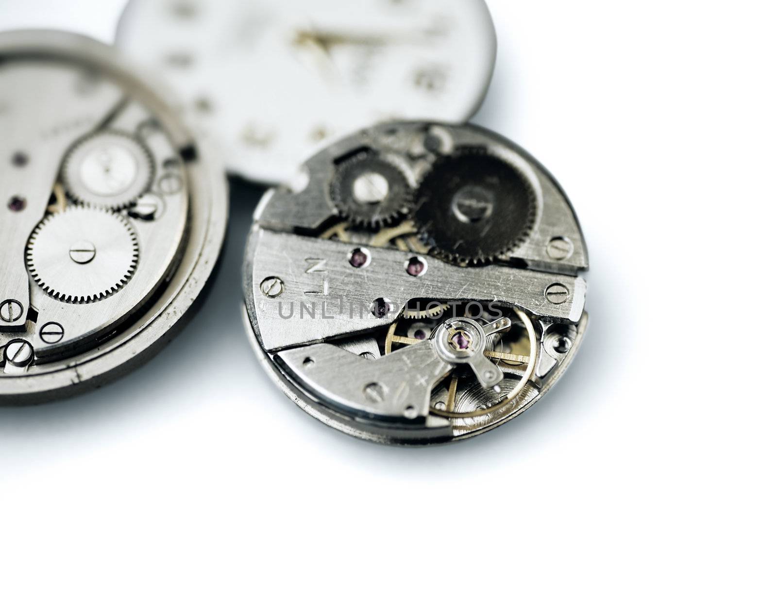 Old metal mechanical clock with gear wheels on a white background