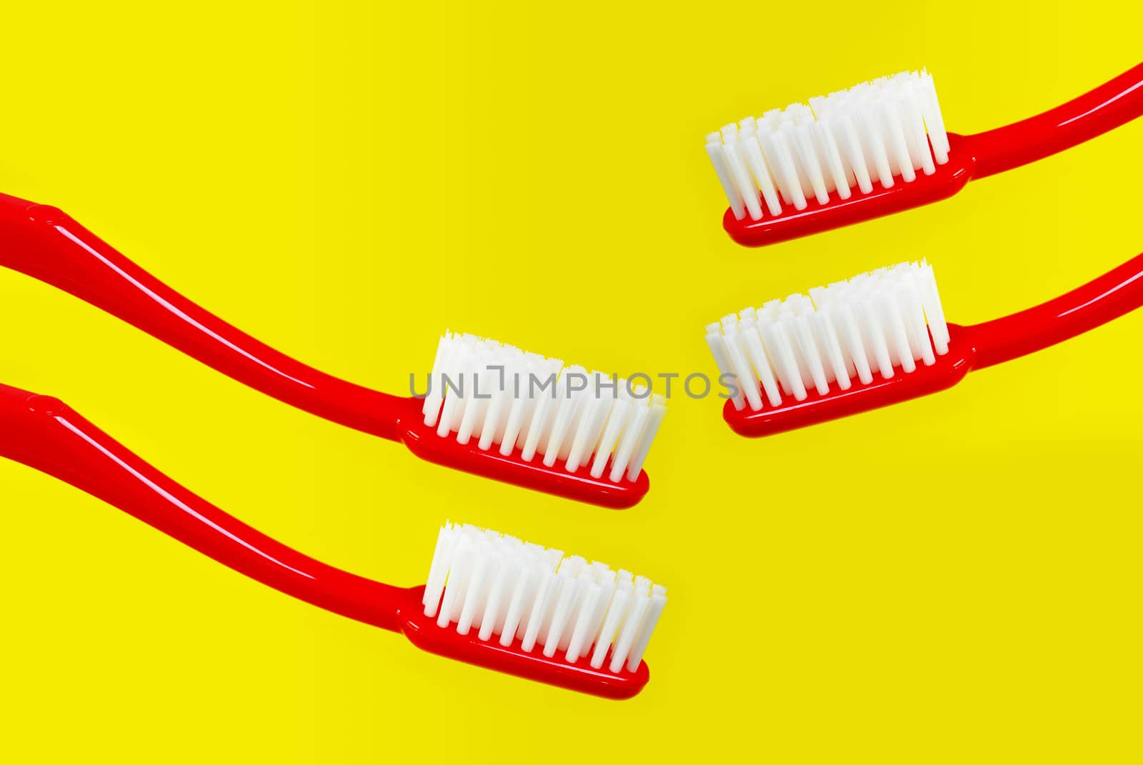 Red toothbrush on yellow background 