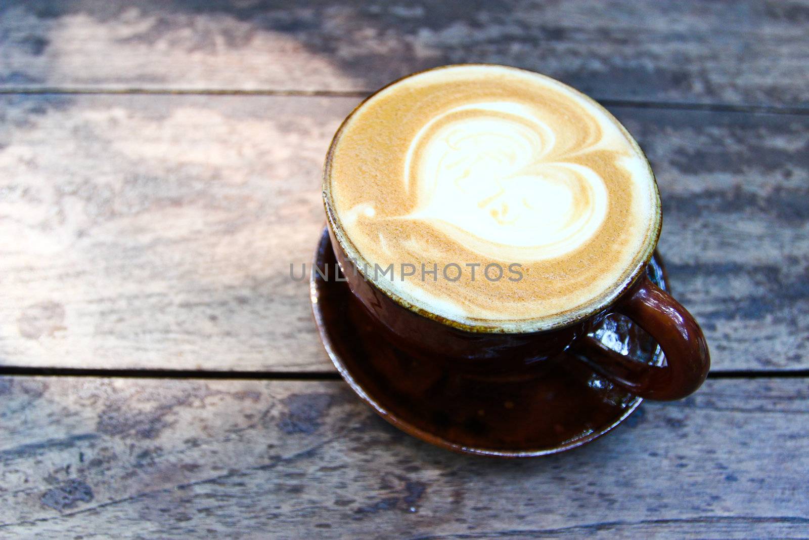 Latte art on a cappucinno , on wooden table by bajita111122