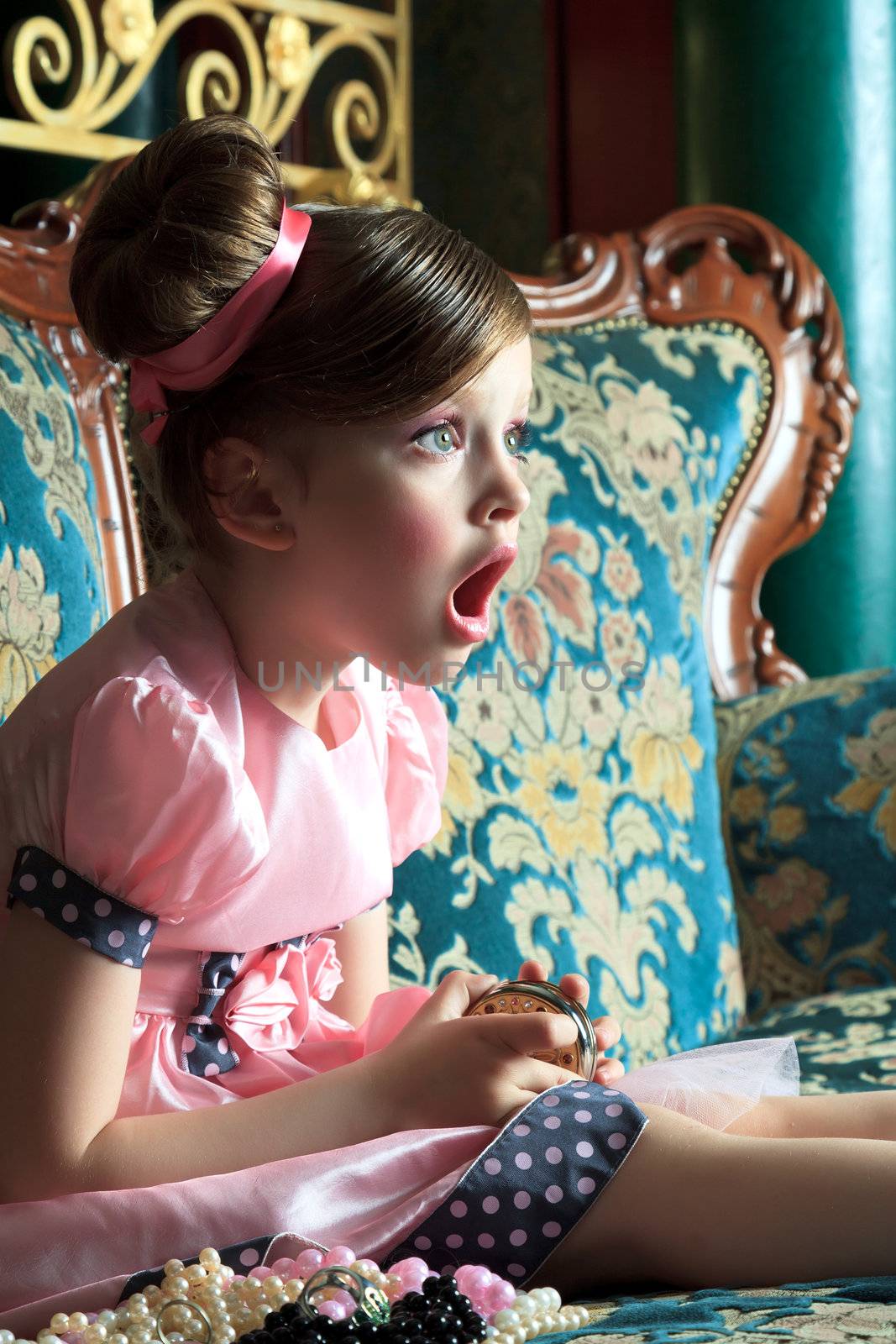 Surprised girl sits with her ​​eyes wide open and mouth