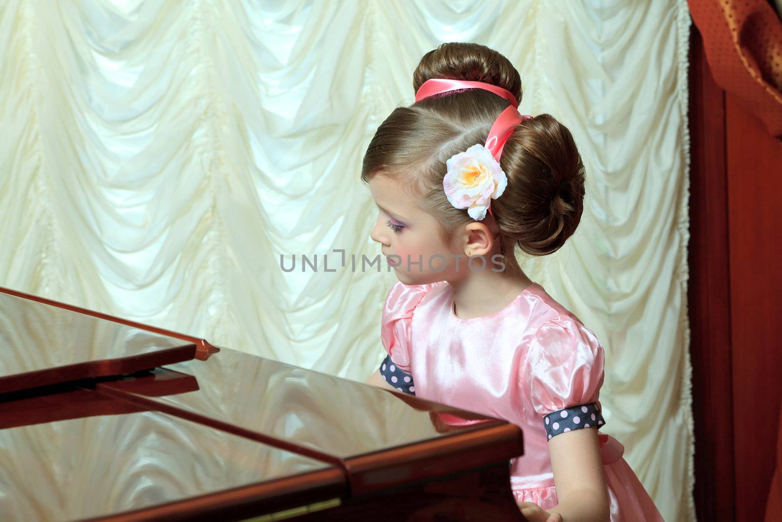 The girl in pink plays the piano