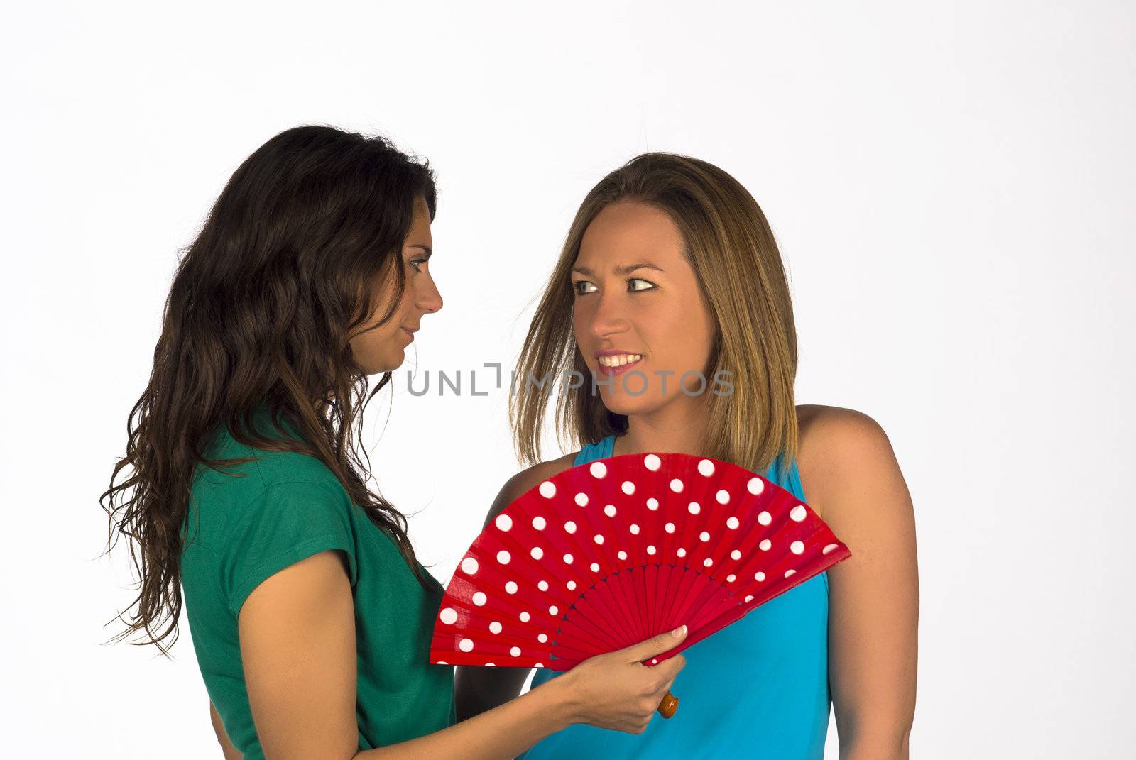 Two girls using a traditional red fan