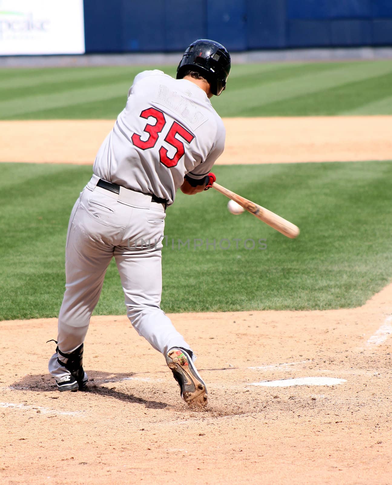 Baseball batter swinging and hitting the ball