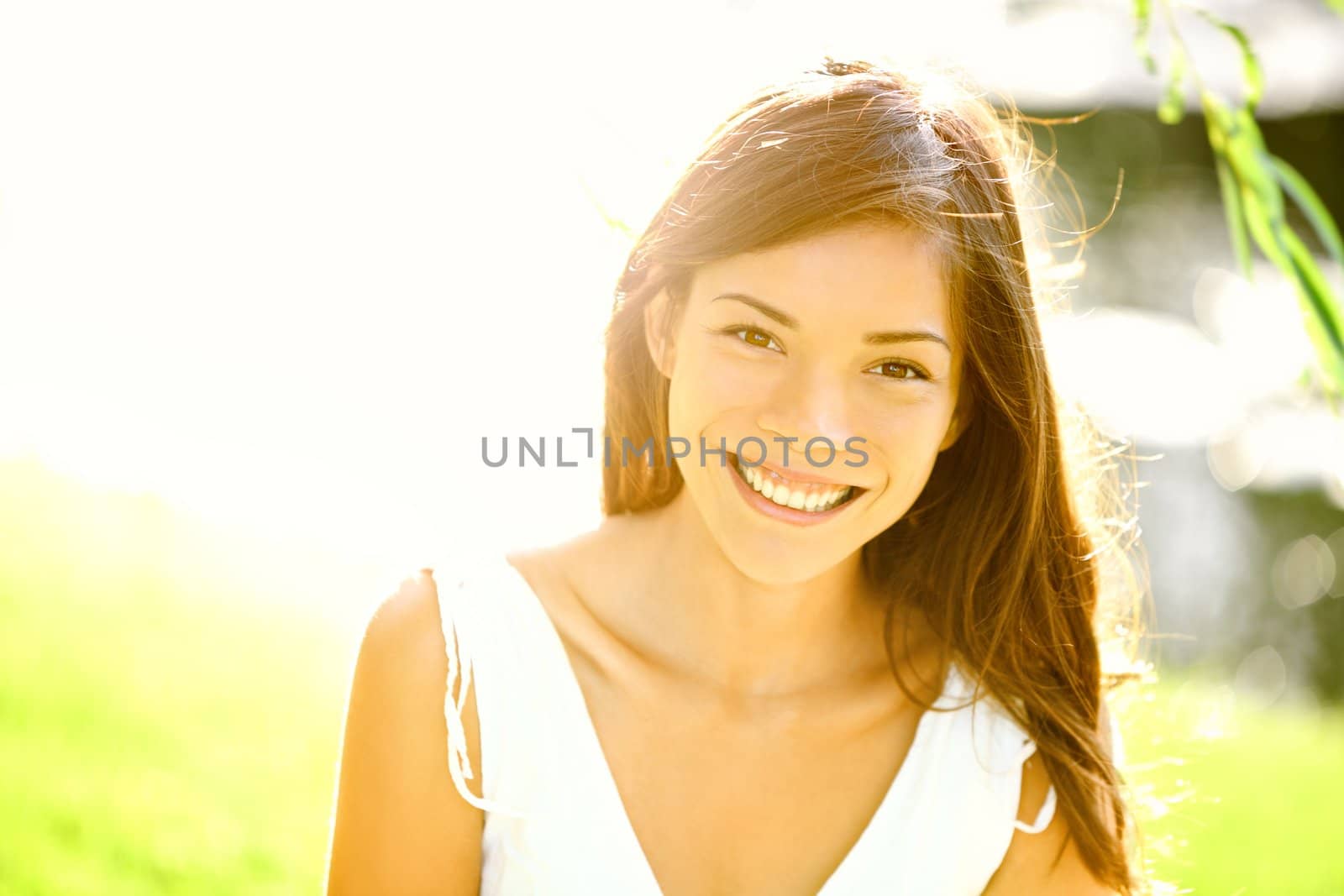 Summer girl portrait. Asian woman smiling happy on sunny summer or spring day outside in park by lake. Pretty mixed race Caucasian / Chinese Asian young woman outdoors.
