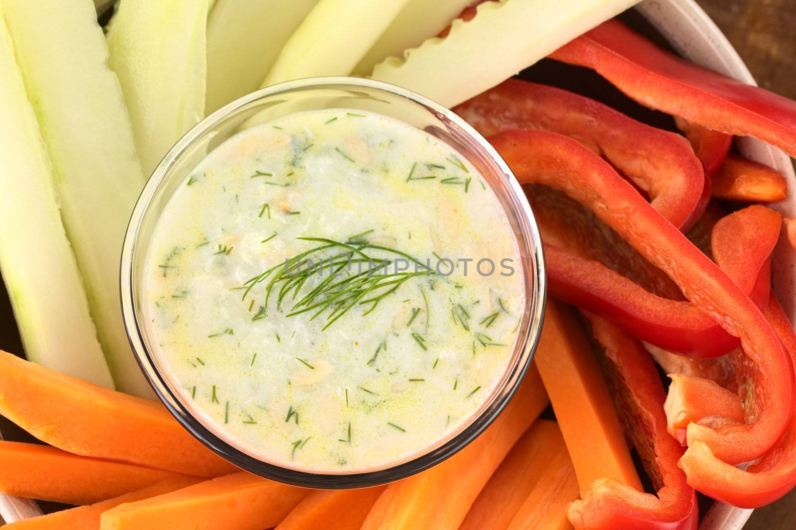 Fresh carrots, cucumbers and pepper with tzatziki dip (Selective Focus, Focus on the dill on the tzatziki)