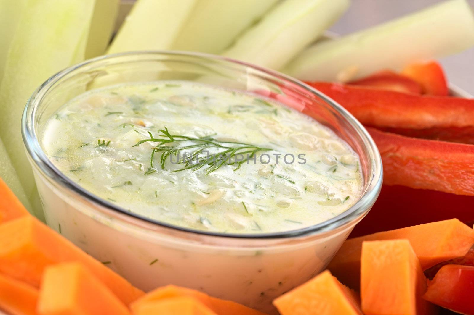 Fresh carrots, cucumbers and pepper with tzatziki dip (Selective Focus, Focus on the dill on the tzatziki)