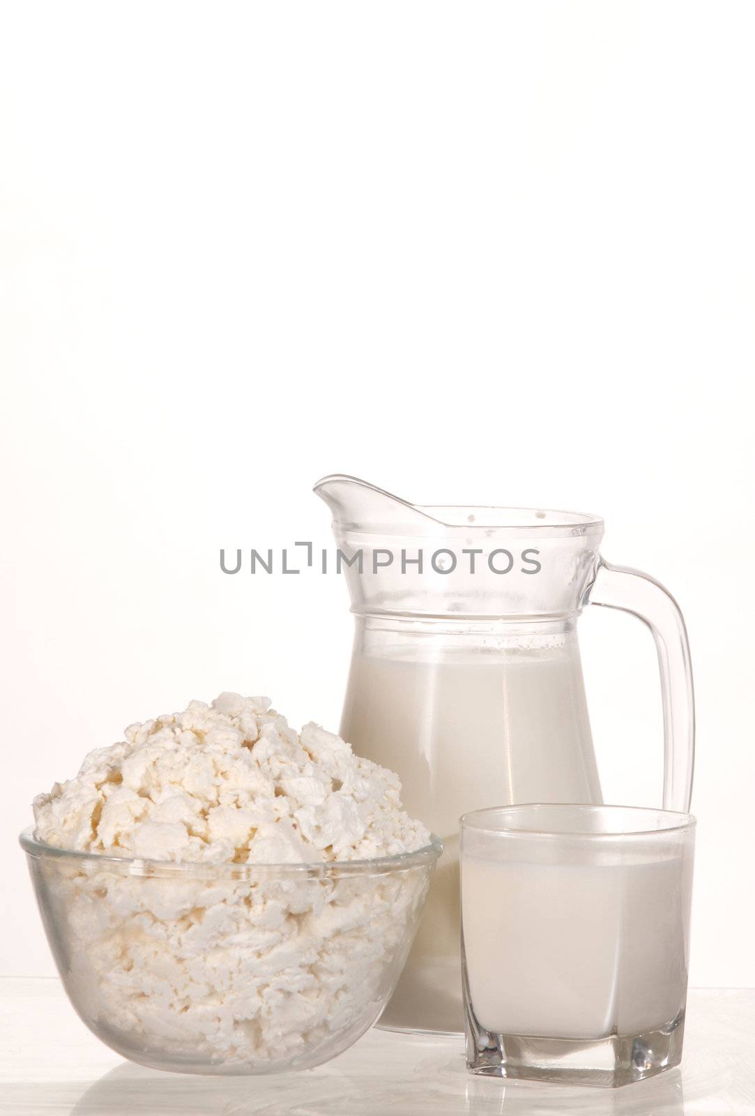 dish with cottage cheese and glass with milk
