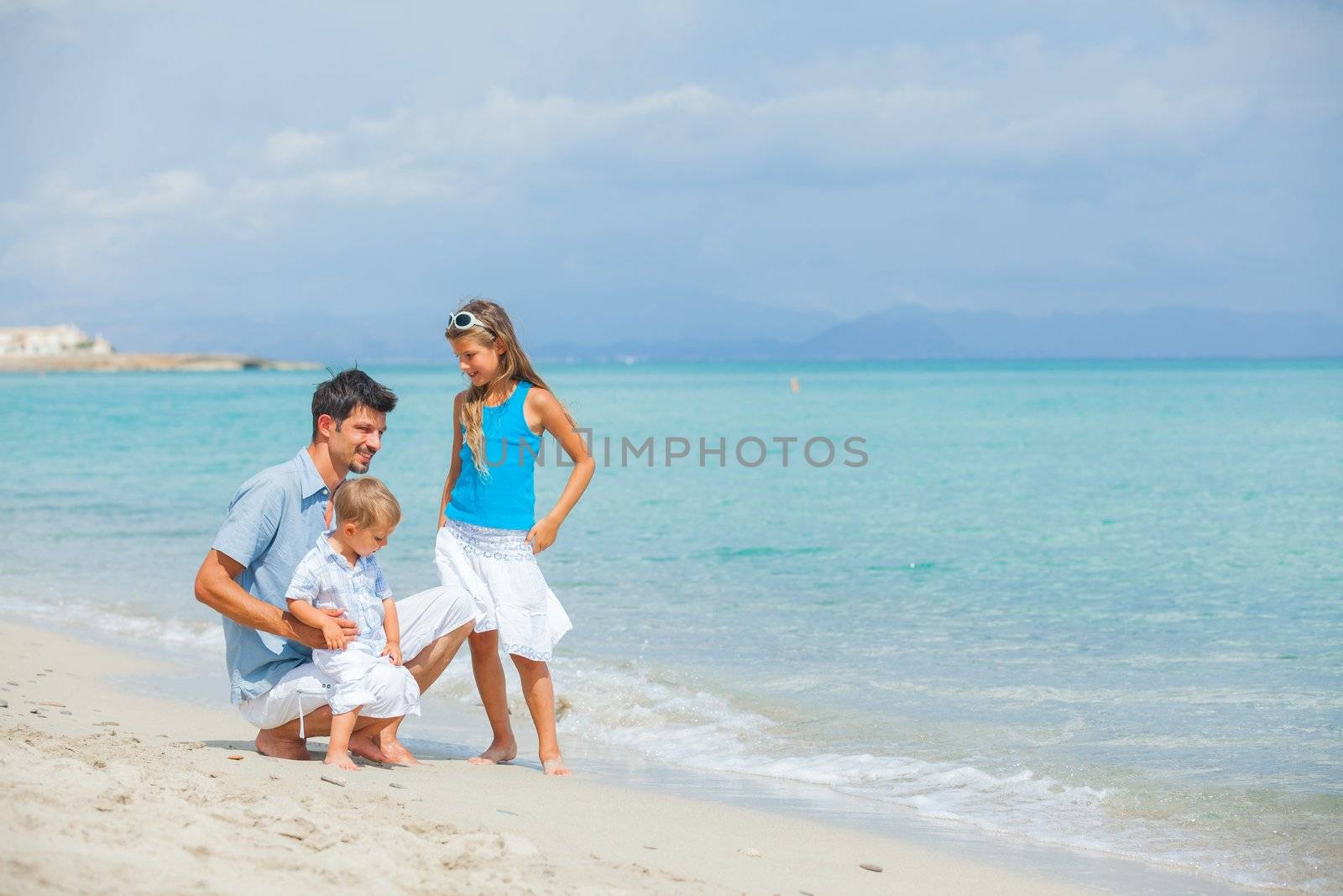 Young father with her two kids on tropical beach vacation