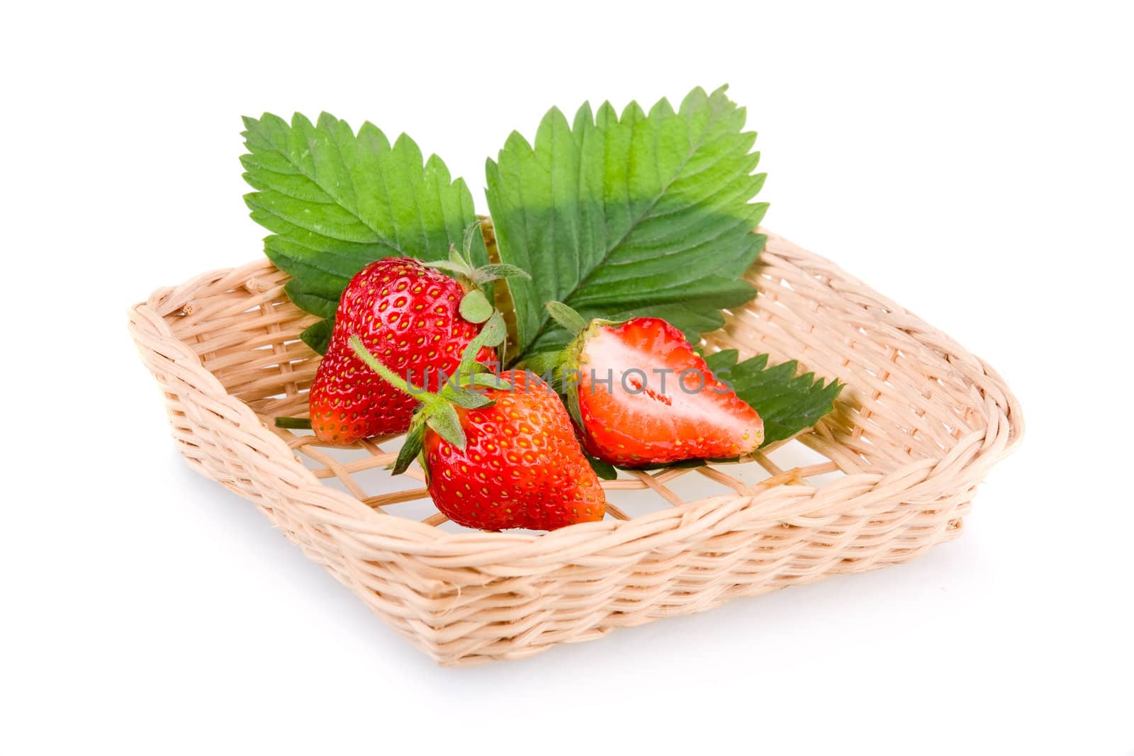 Basket of red strawberry fruits with green leaves isolated on white background 