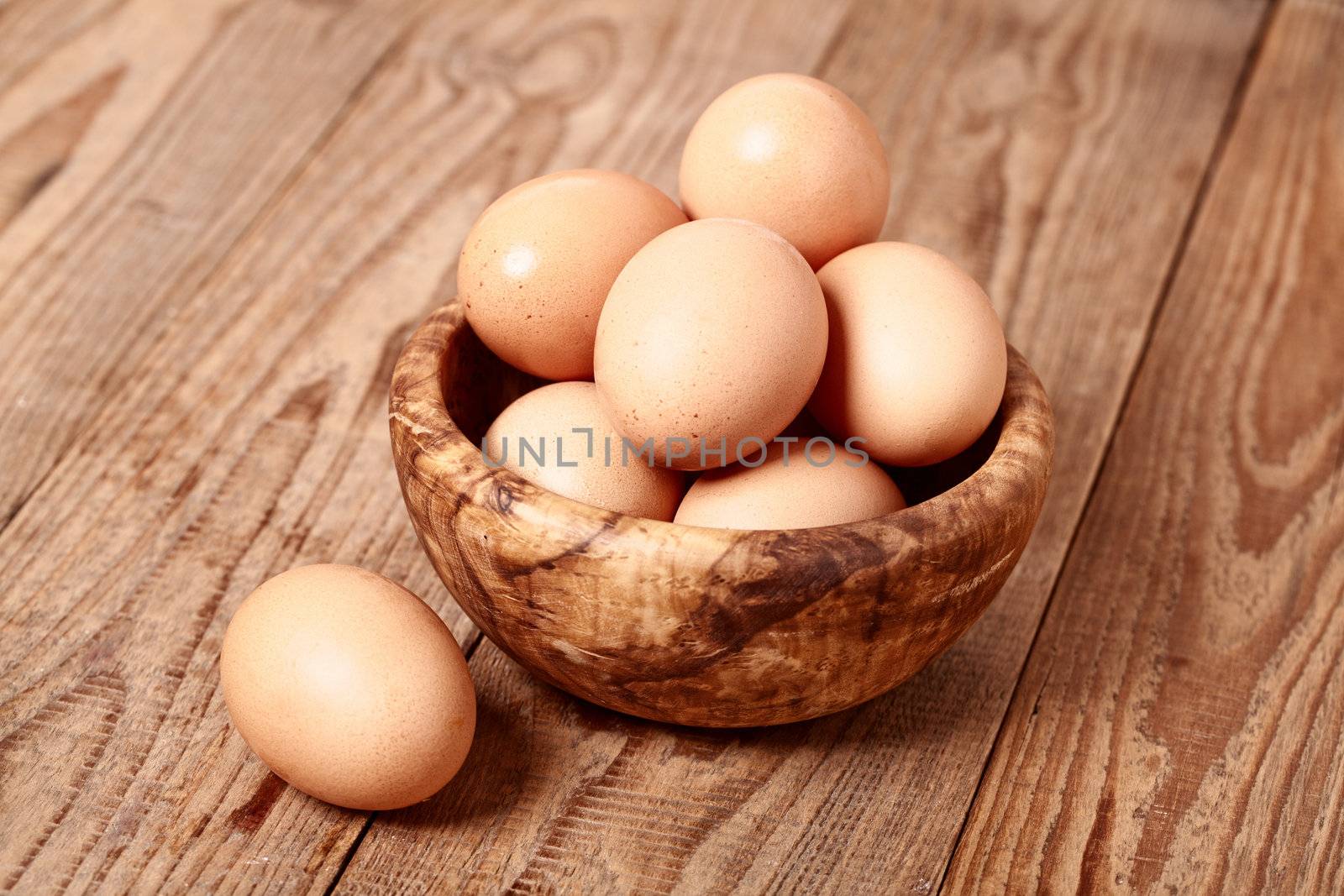 fresh brown eggs on wooden background  by motorolka