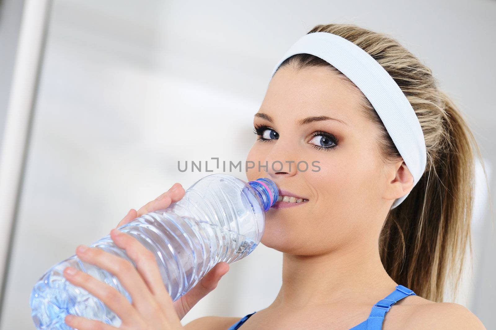 young sportive adult is drinking fresh water