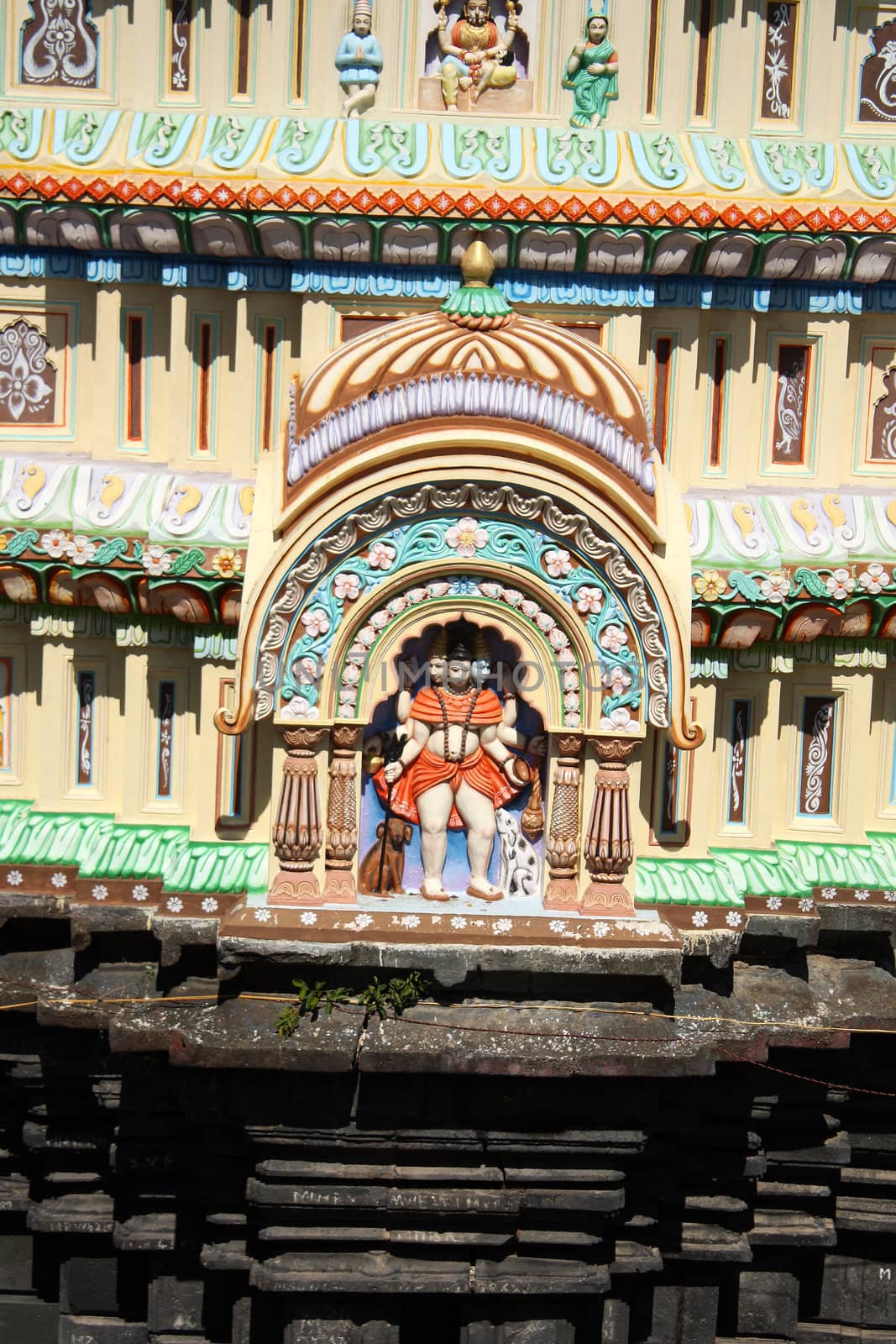 A beautiful idol of lord dattatreya also known as gurudatta or dattaguru, on an ancient temple dome.