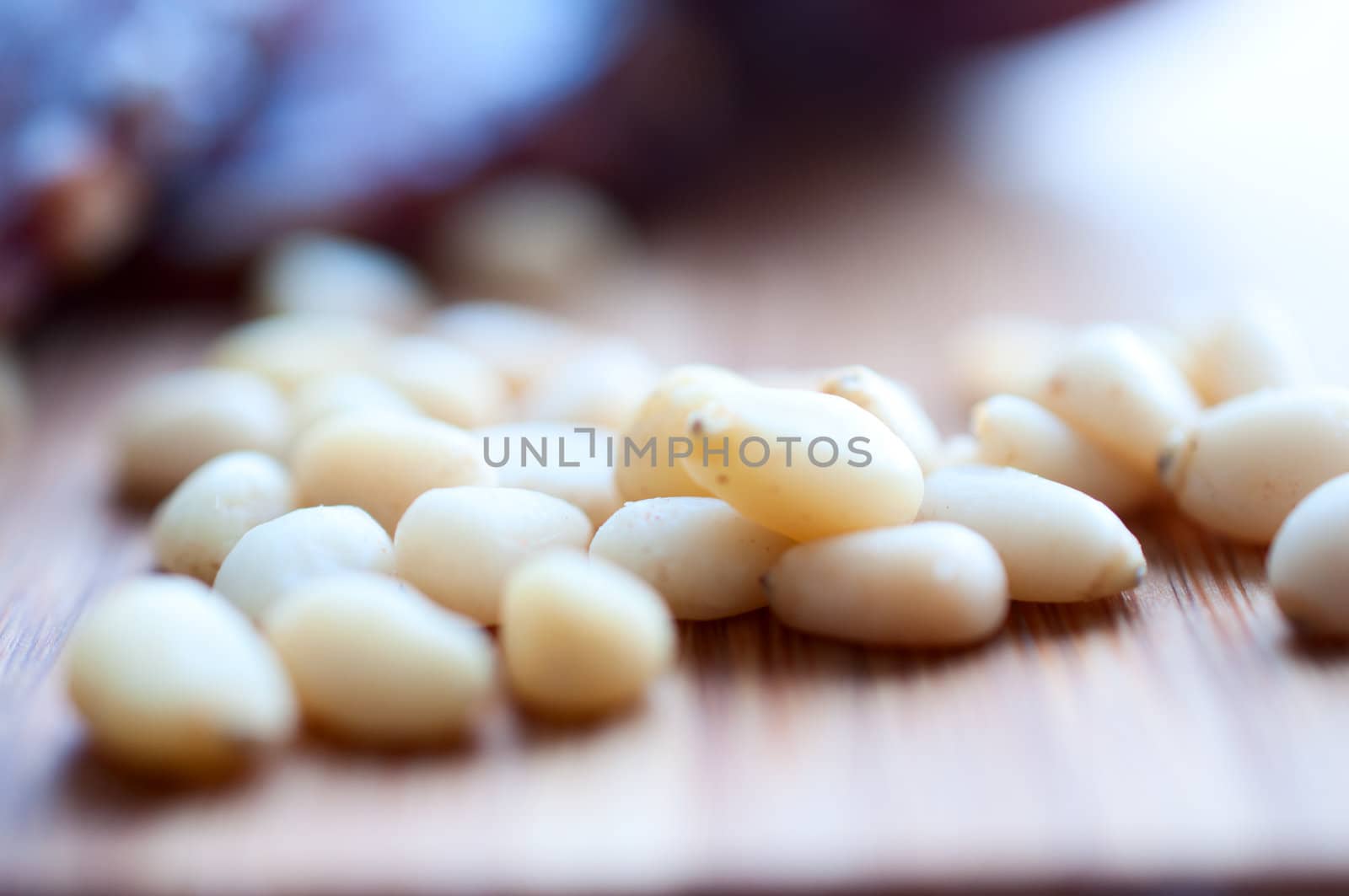 Shelled pine nuts on a wooden board by Nanisimova