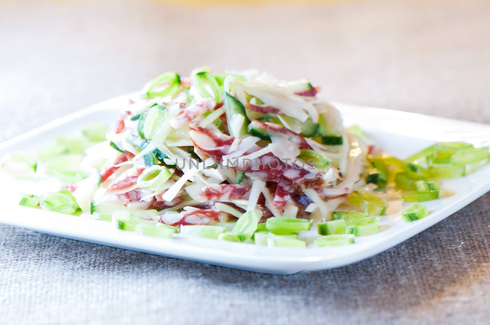 Cabbage salad, sausage, cucumber and green peas close up