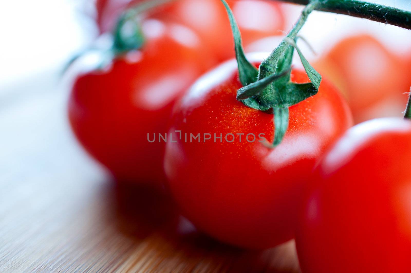 Red cherry tomatoes on a cutting  by Nanisimova