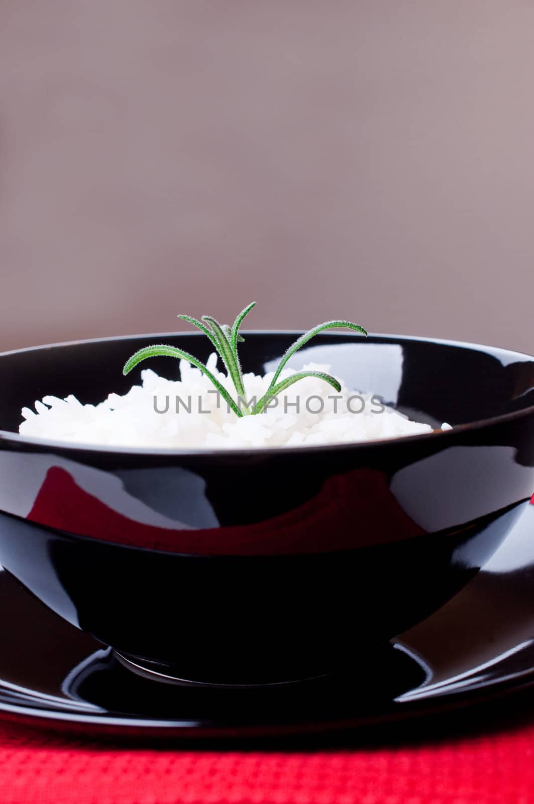 White rice in black round bowl on red tablecloth