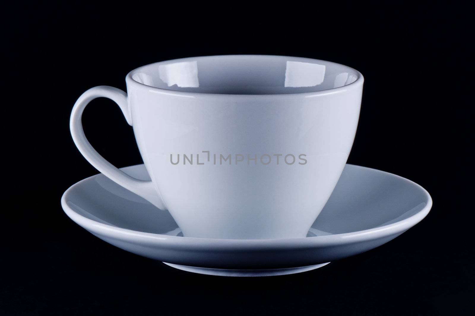 White cup on saucer black background