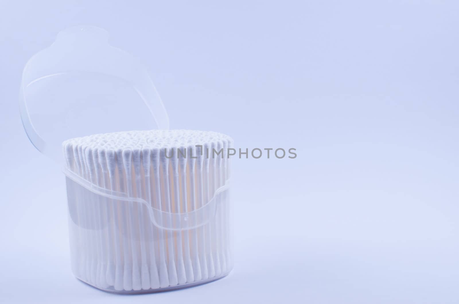 Cotton buds in open transparent plastic box with lid