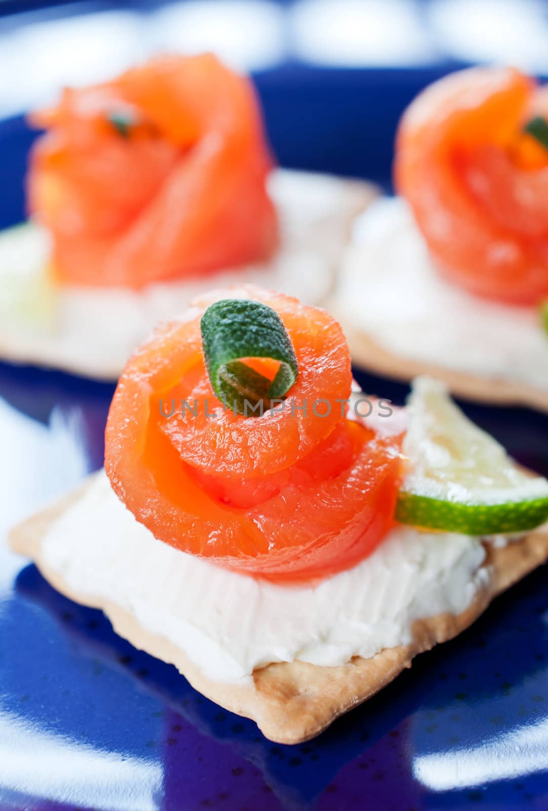 Canapes with smoked salmon and cream cheese on blue background