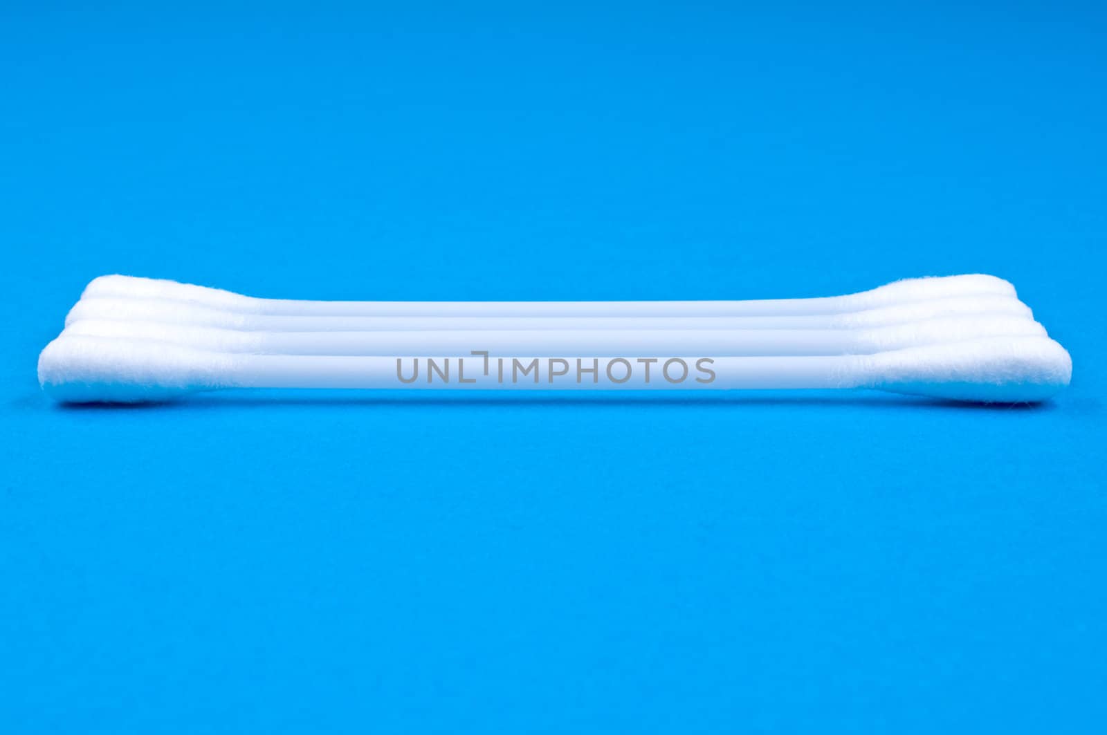 Four cotton buds on blue  background close up