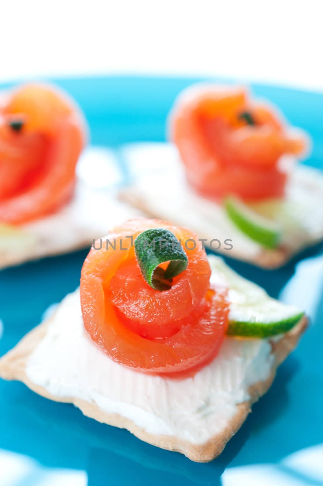 Canapes with smoked salmon and cream cheese on blue plate