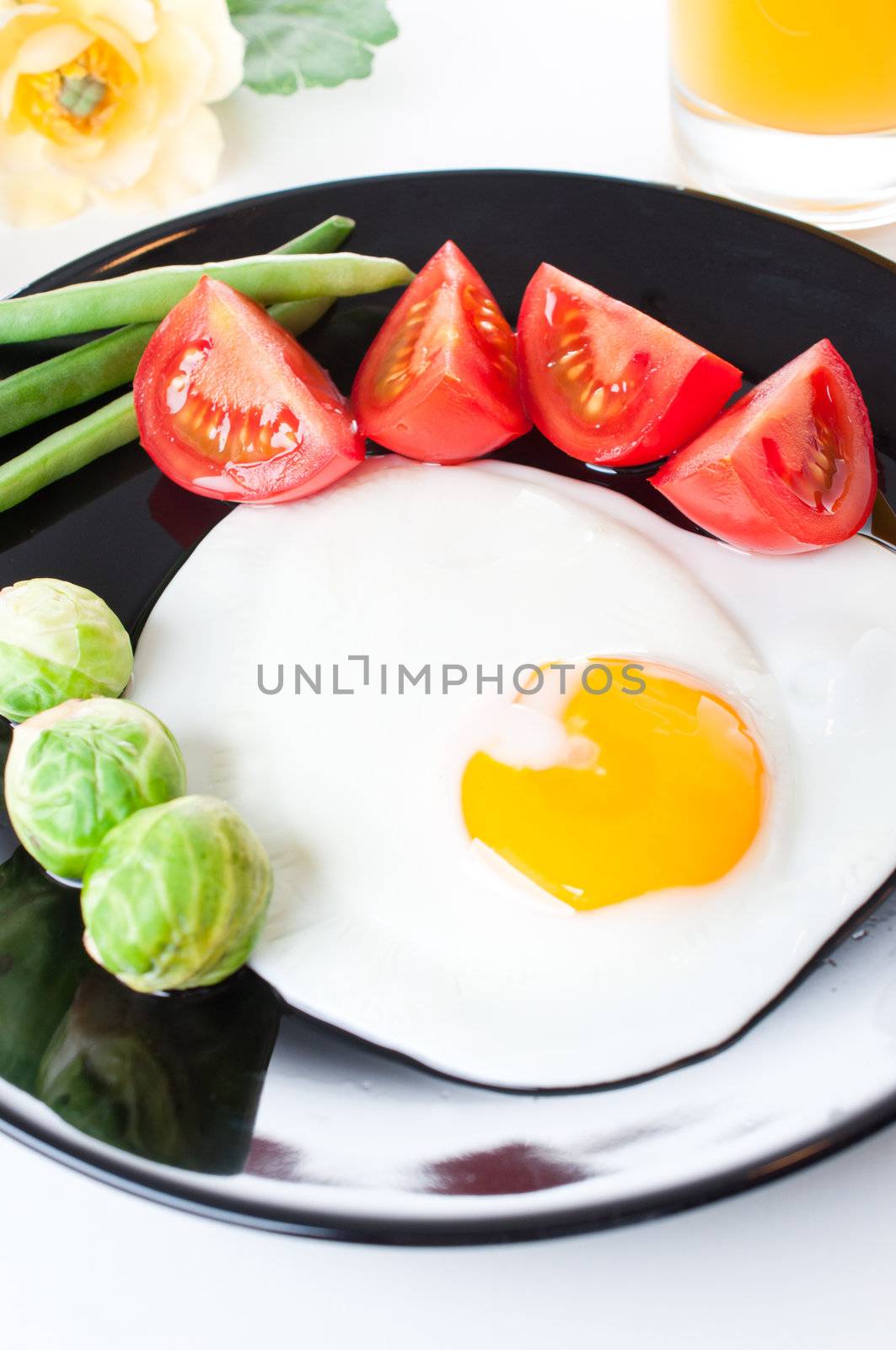 Fried egg with vegetables for breakfast on white background