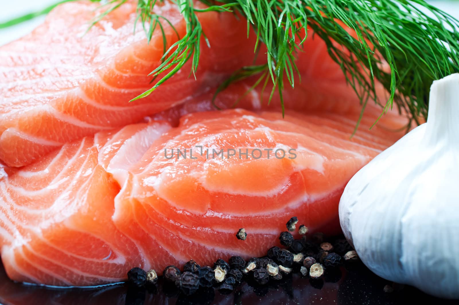 Salmon with black pepper and garlic on plate close up