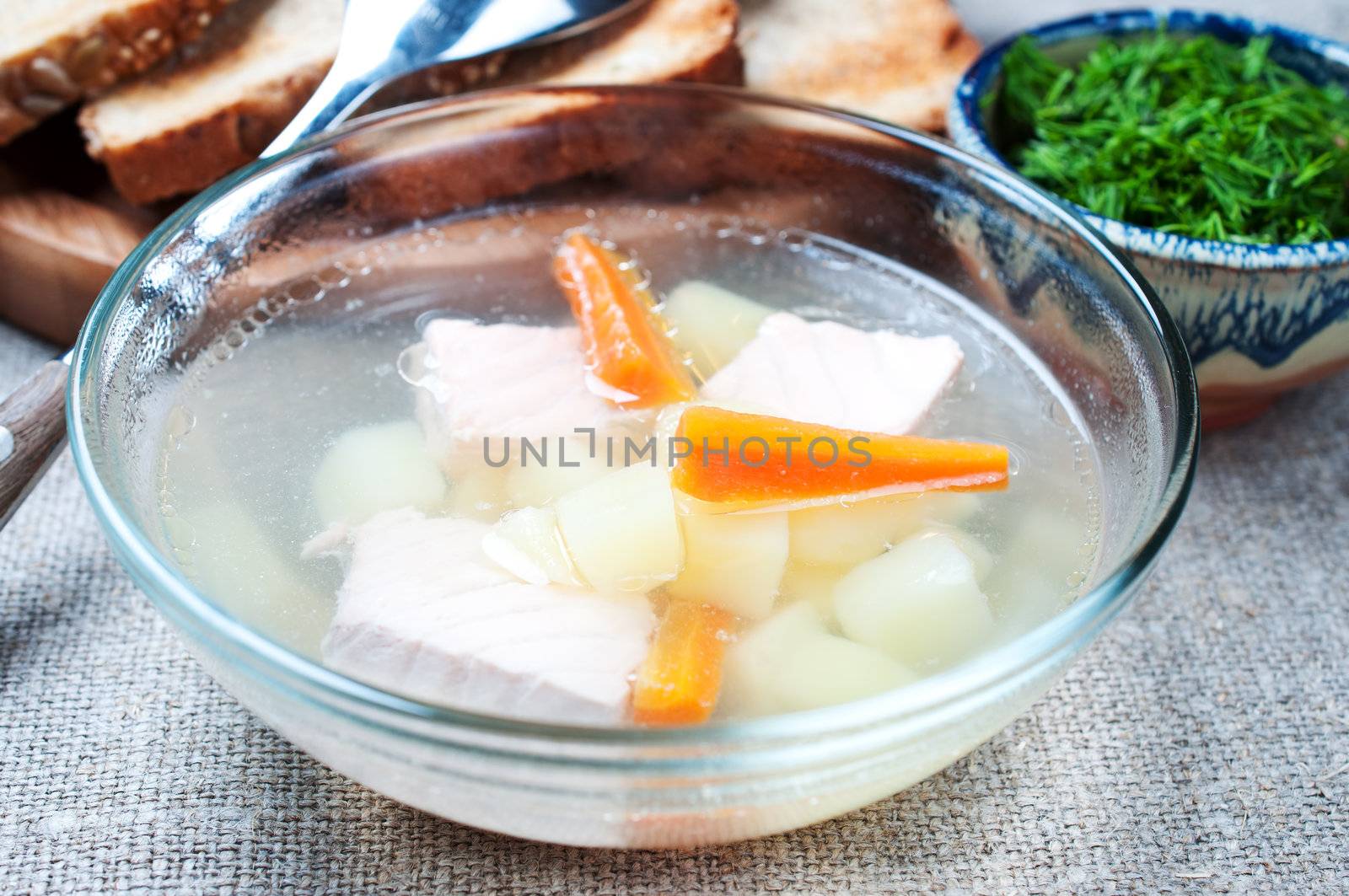 Vegetable soup with salmon in glass bowl