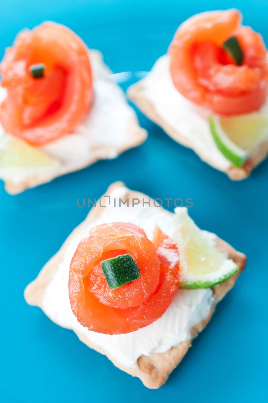 Canapes with smoked salmon on blue background