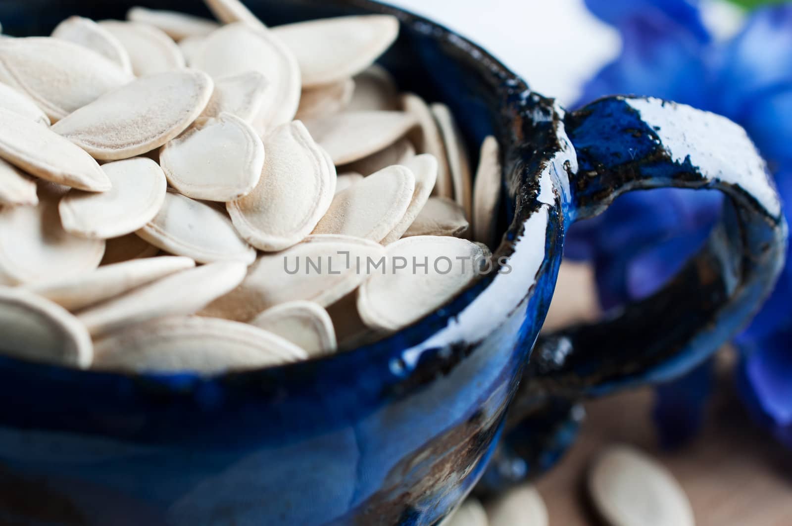Pumpkin seeds in the blue bowl by Nanisimova