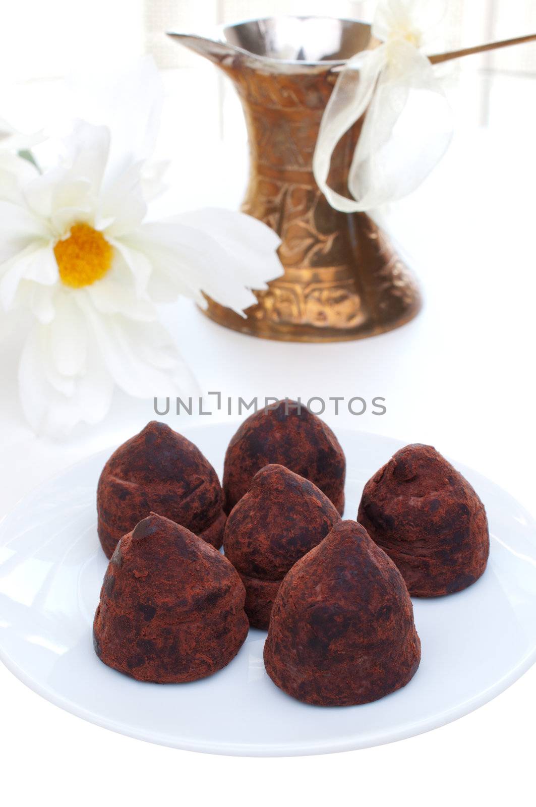 Six truffles on a plate  turish coffee pot on background