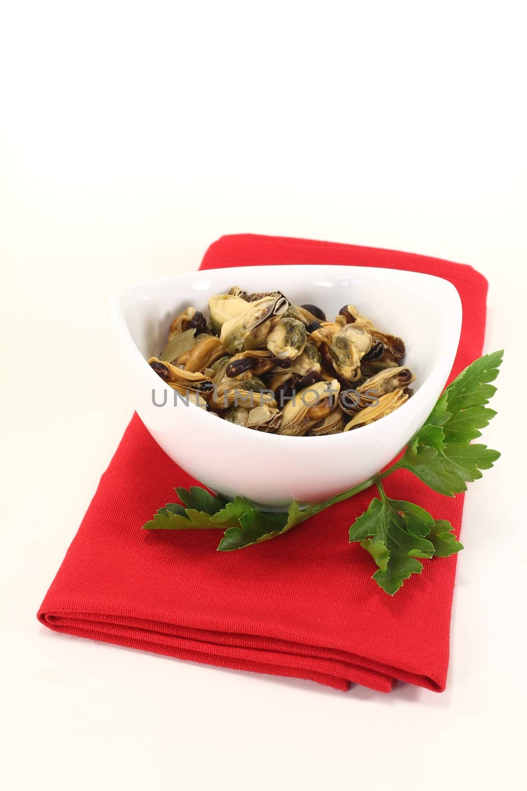 marinated mussels with italian parsley in a bowl on bright background