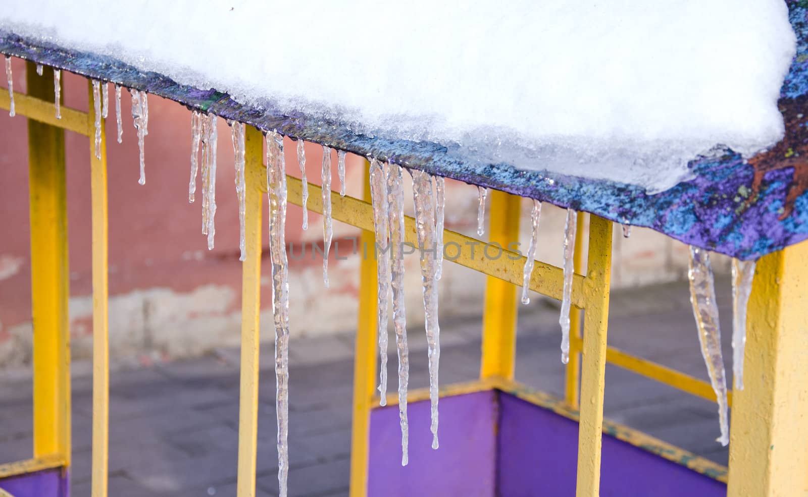 Melting icicles spring on roof playground house. by sauletas