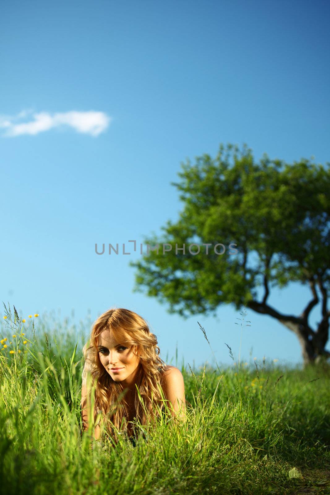 blonde lays under the tree 