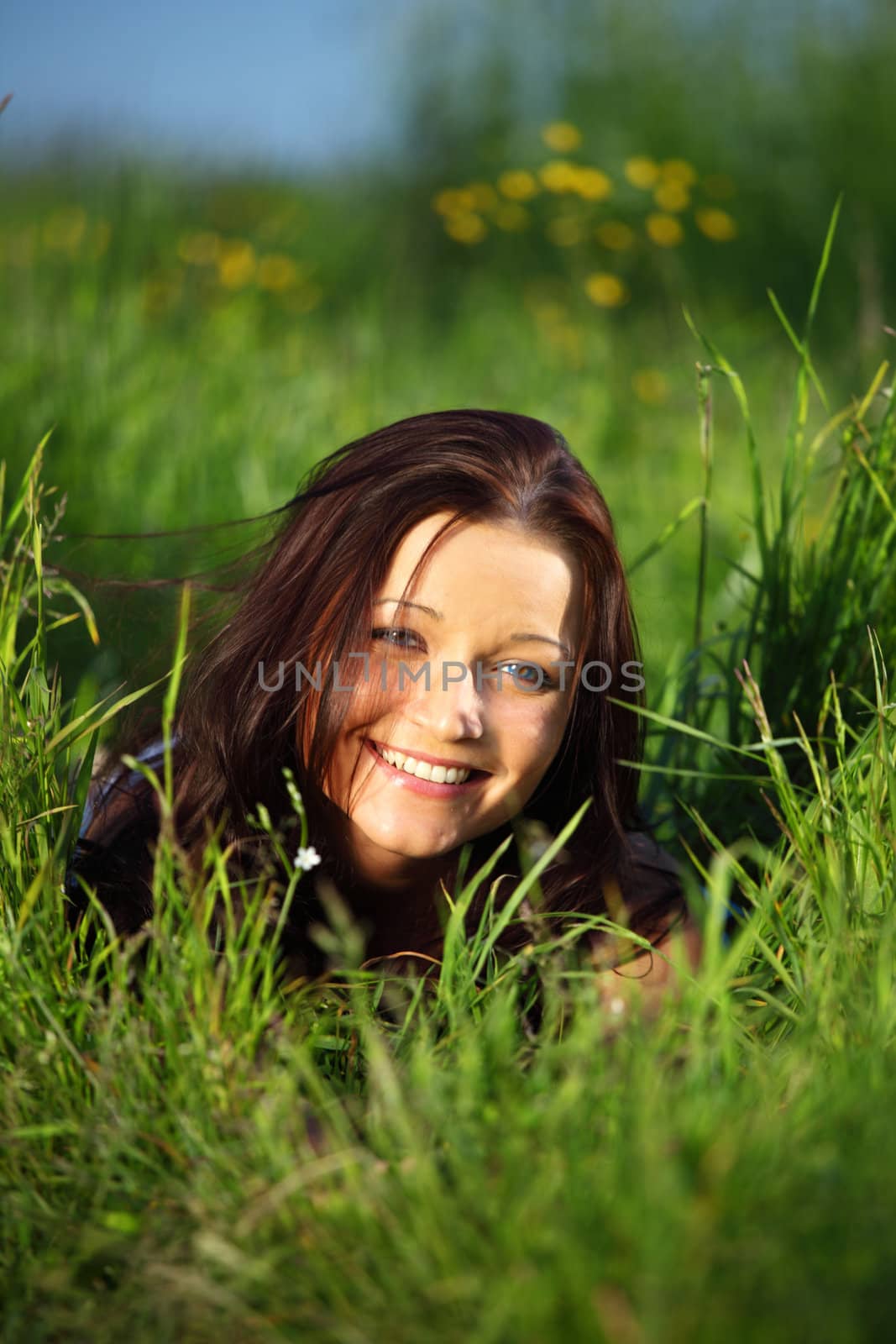 brunette lays on green grass