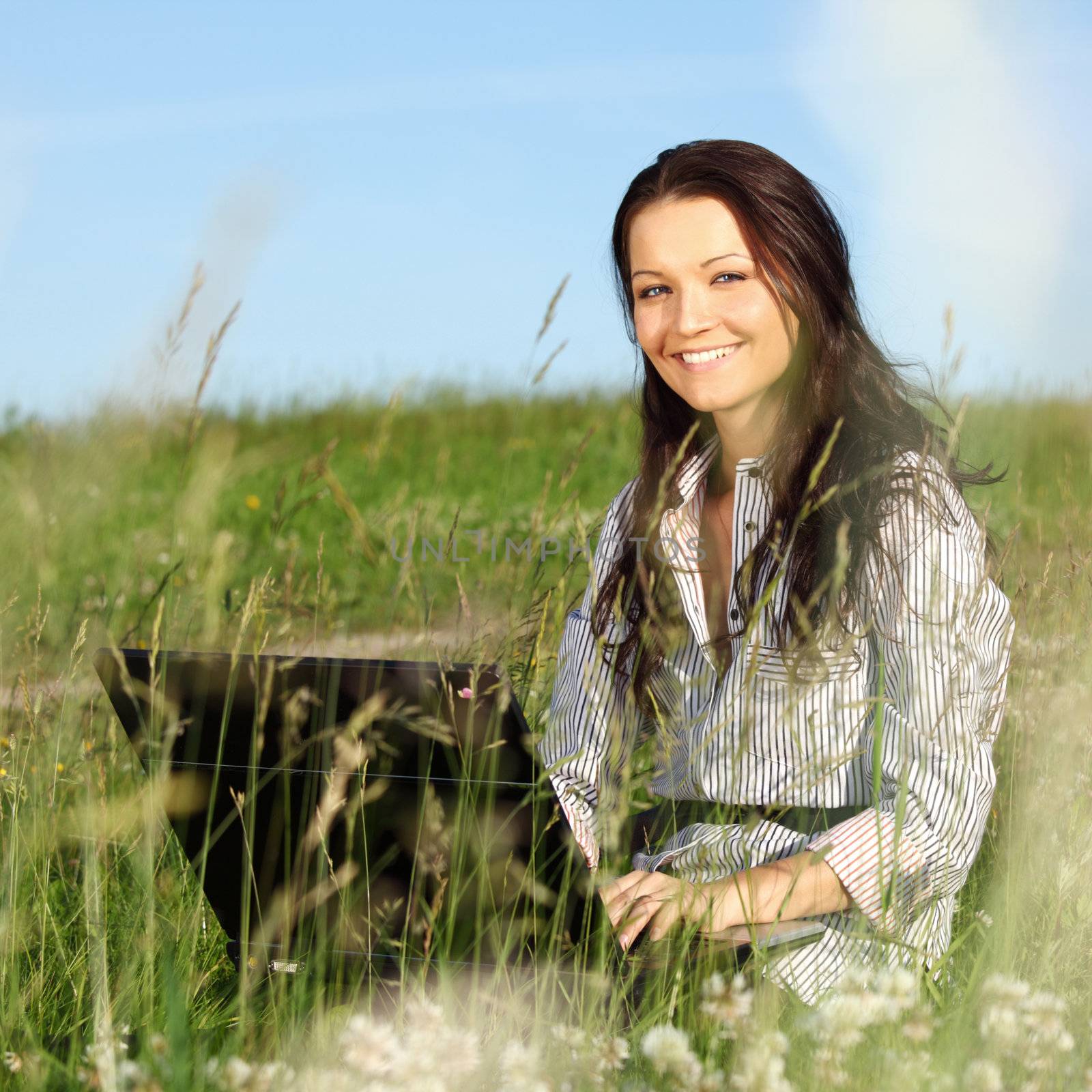 woman on green field work on laptop