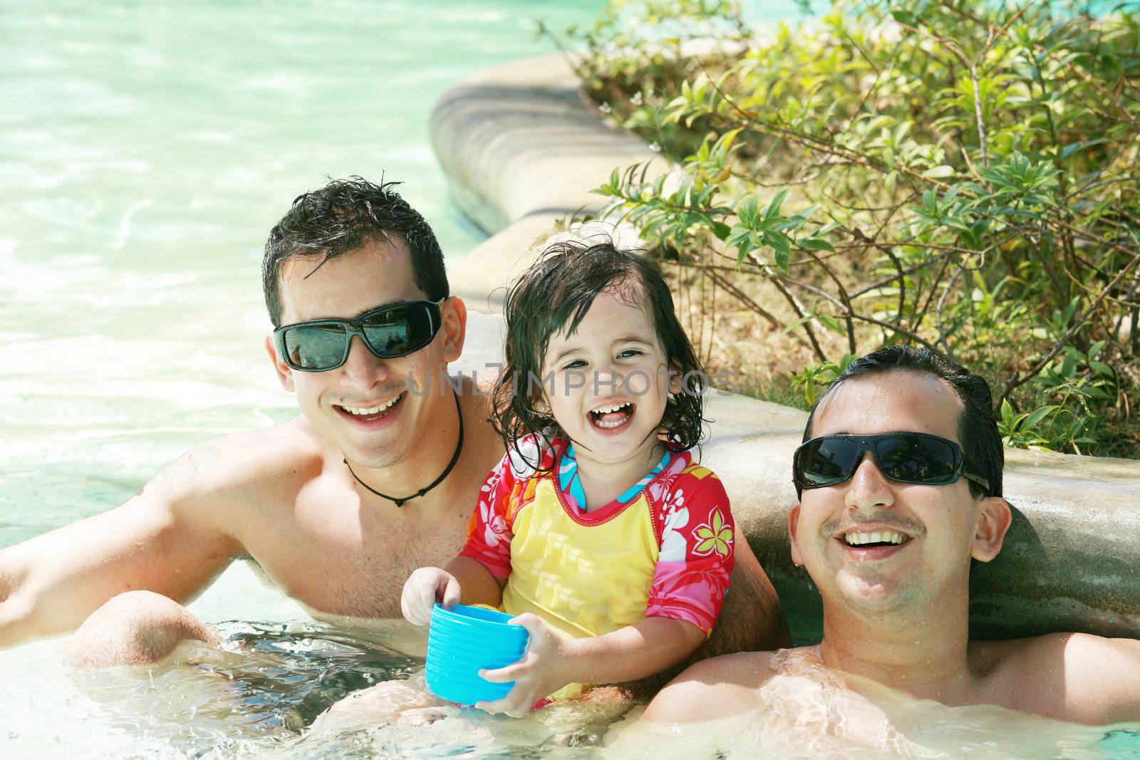 Happy family having fun in swimming pool. Brothers and niece having fun in the pool on summer vacation