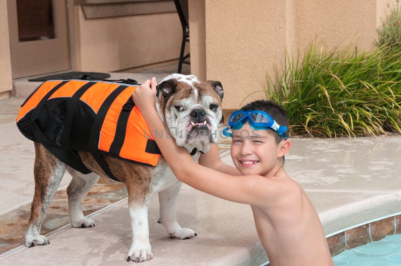 Kid and his pet bulldog playing near the pool