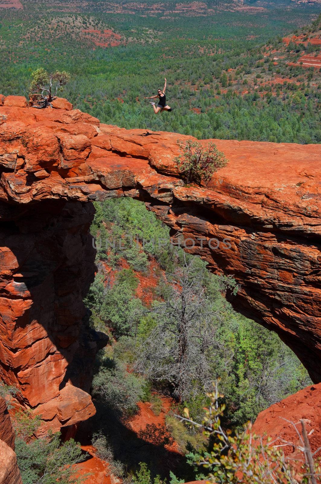 Hiker girl jumping in Devils bridge, Sedona Arizona