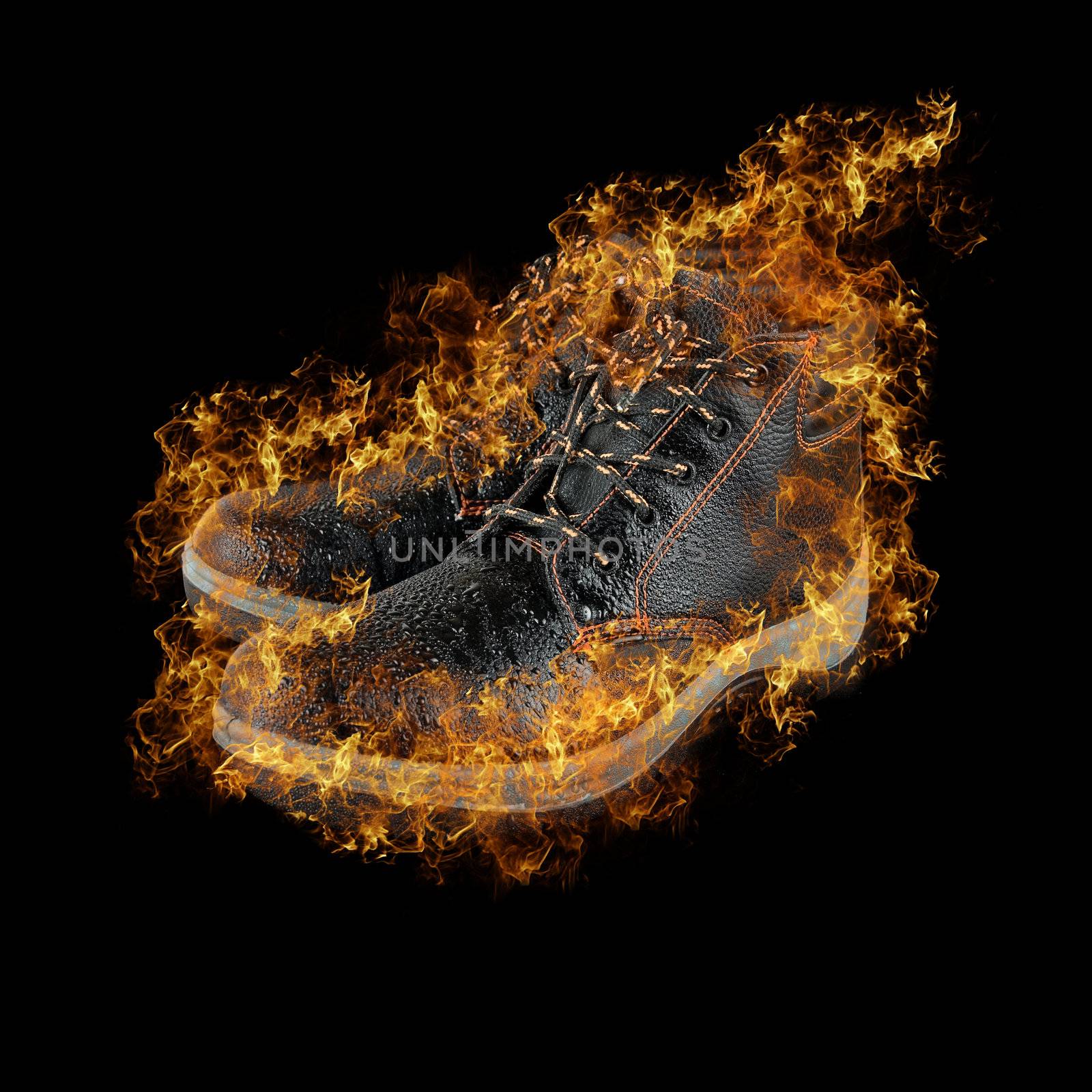 moist modern working boots at fire isolated on a black background