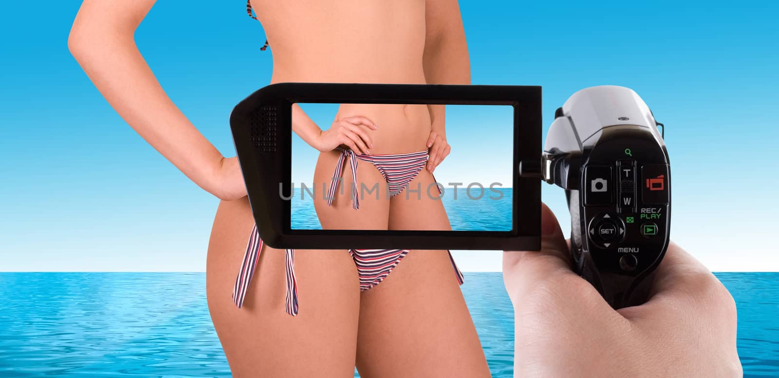 Girl at bikini closeup on nature background posing to Digital Camcorder