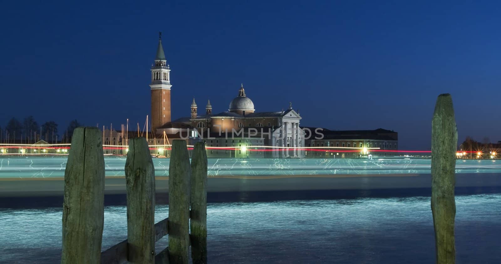 View on the island of San Giorgio in Venice in the winter night with the lights of passing ships traces