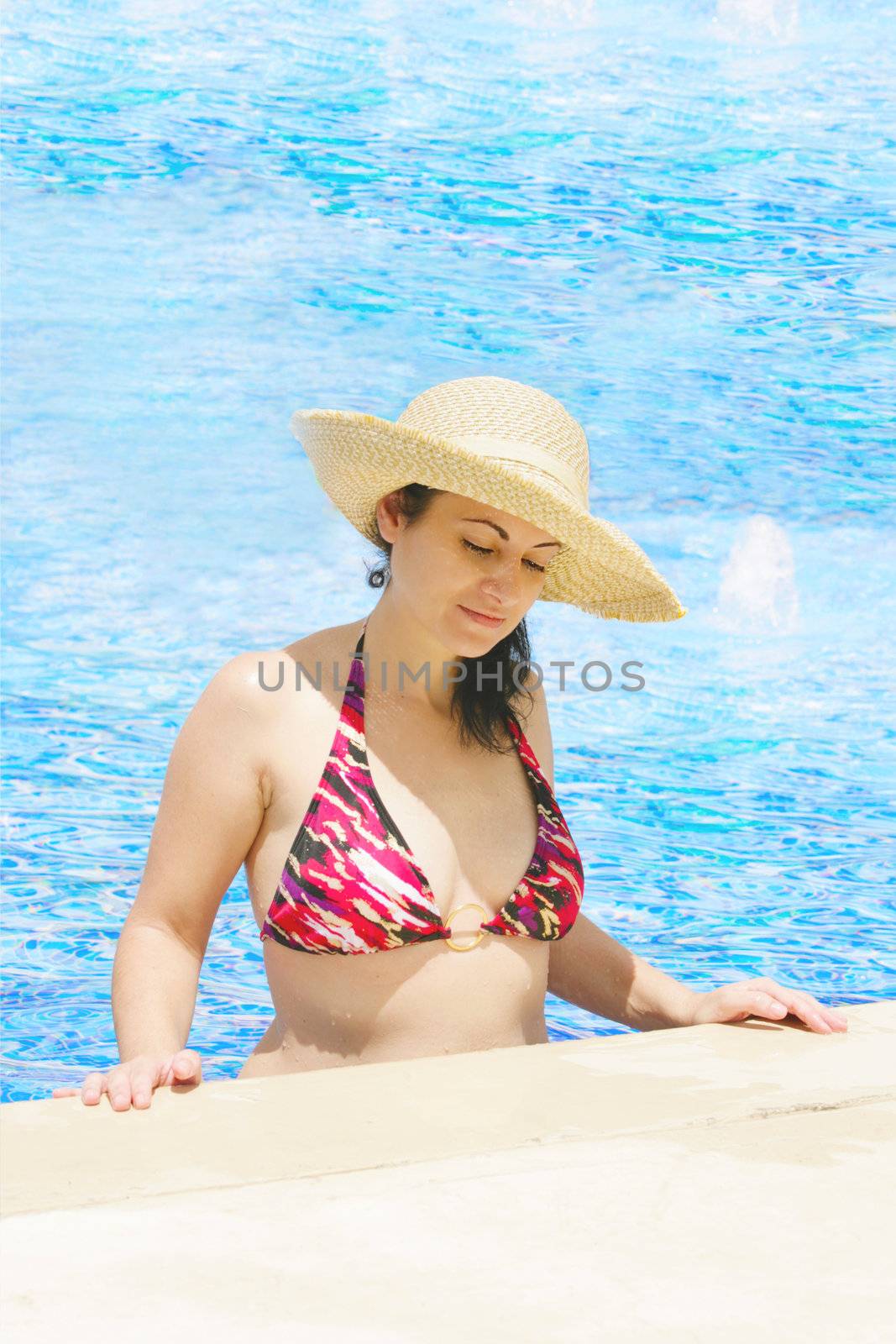 The beautiful woman in a hat in pool by dacasdo